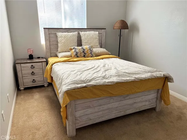 a bed sitting in a bedroom next to a window