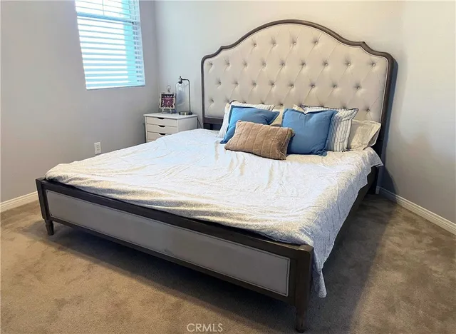 a bed sitting in a bedroom next to a window