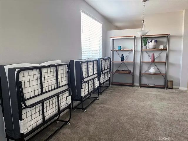 a view of an empty room with windows & cabinet