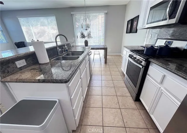 a kitchen with a sink a stove a refrigerator and cabinets