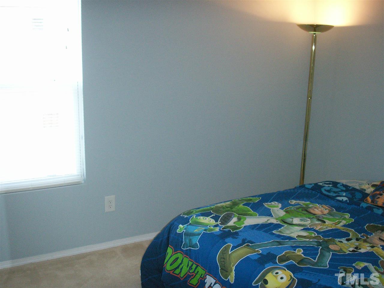 3129 Varcroft Road Knightdale, NC 27545 - Photo 20 of 25 a bedroom with a bed and a lamp on the dresser