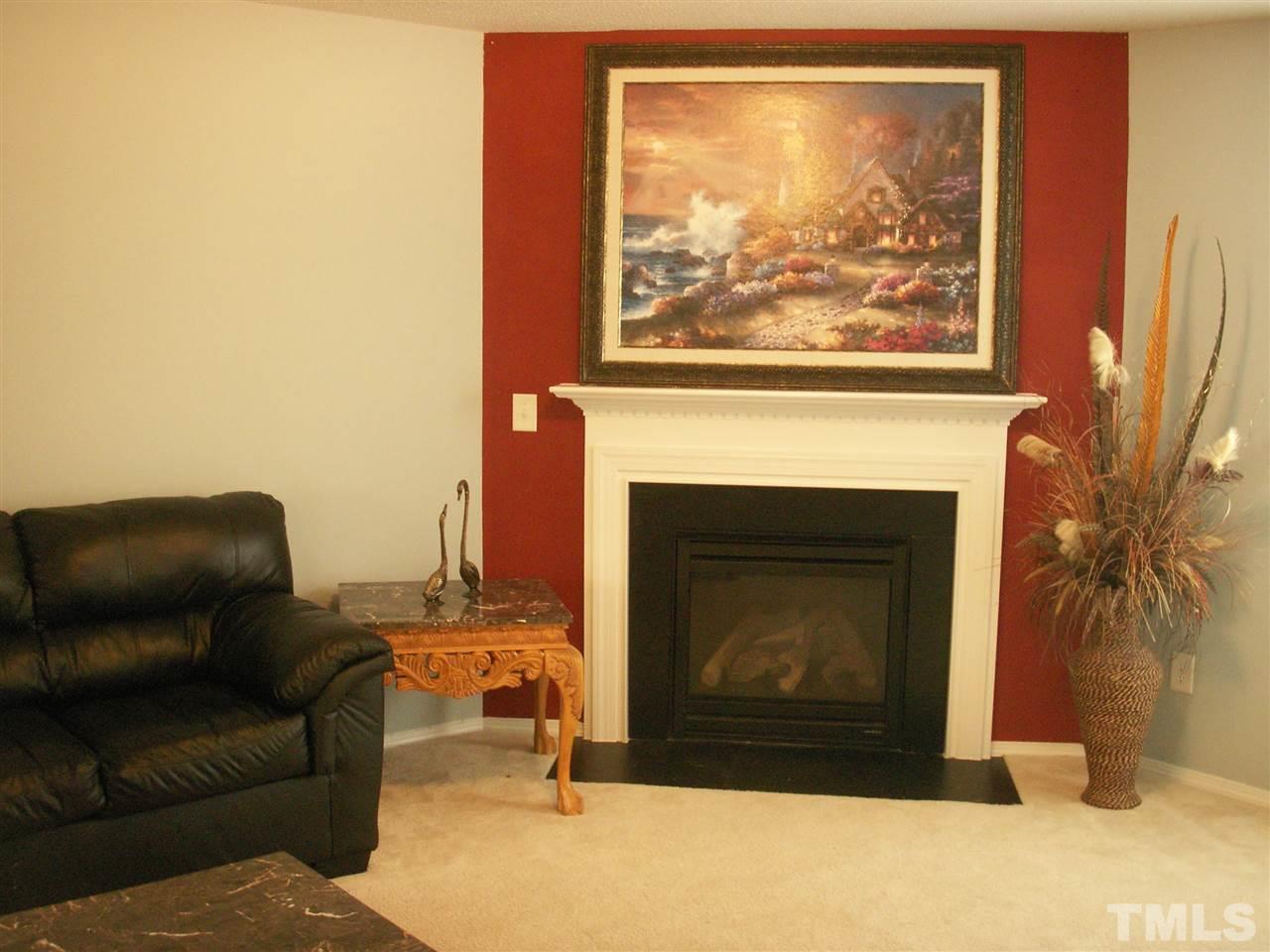 3129 Varcroft Road Knightdale, NC 27545 - Photo 5 of 25 a living room with furniture a flat screen tv and a fireplace