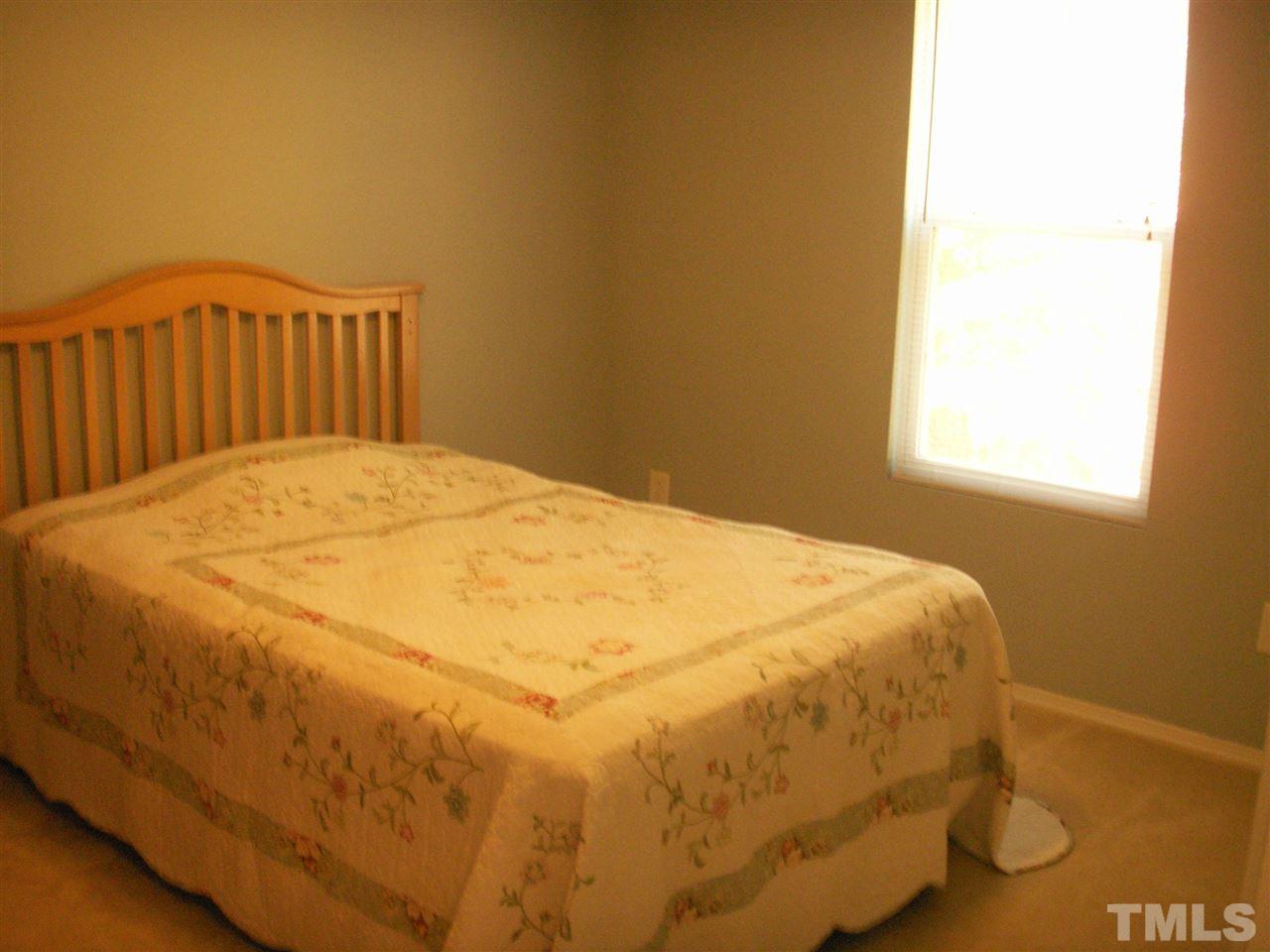3129 Varcroft Road Knightdale, NC 27545 - Photo 8 of 25 a large bed sitting in a bedroom next to a window