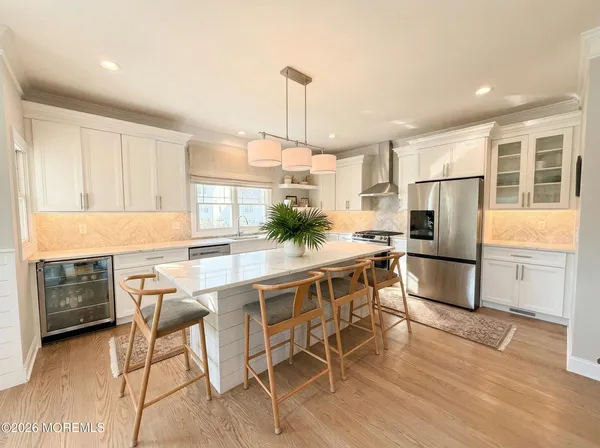 a large kitchen with kitchen island granite countertop a stove a sink a oven and a dining table with wooden floor