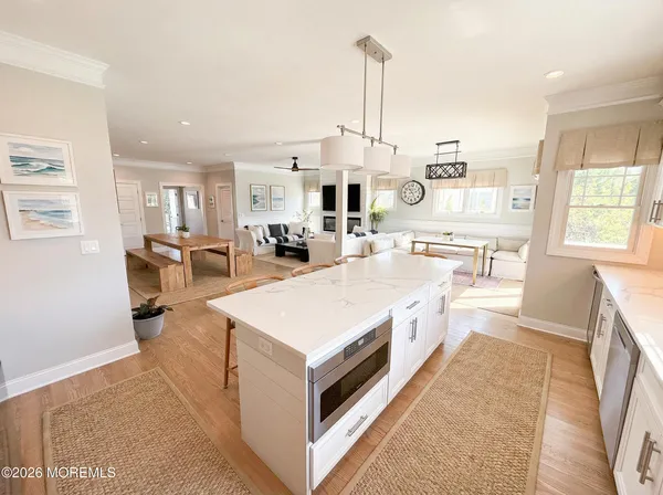 a large white kitchen with a large window a sink and stainless steel appliances
