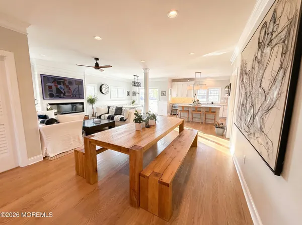 a dining hall with stainless steel appliances kitchen island granite countertop a sink and wooden floor