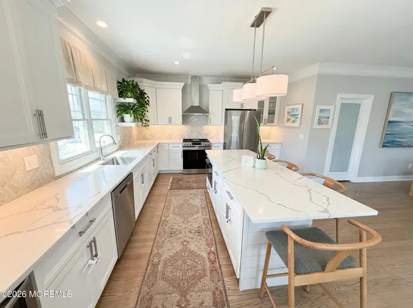 a kitchen with stainless steel appliances a stove a sink island and a refrigerator