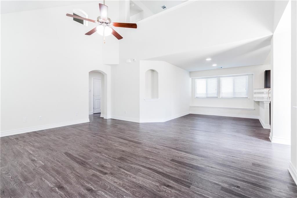 2104 Pindos Pony Way Georgetown, TX 78626 - Photo 6 of 30 A spacious living area features high ceilings, recessed lighting, and durable wood flooring.