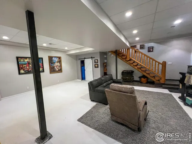 a living room with couches and a dining table with wooden floor