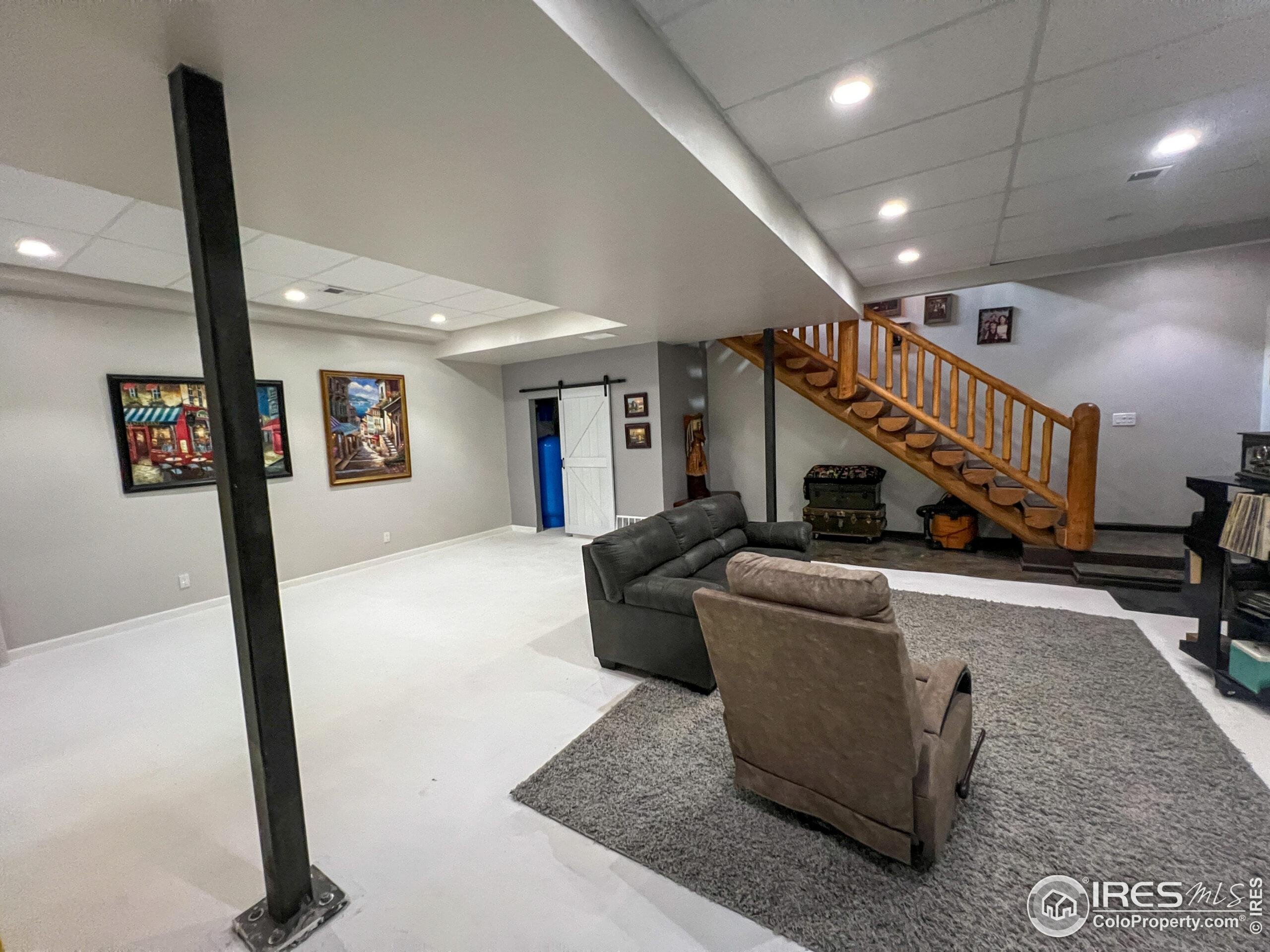 27667 Buckhorn Road Bellvue, CO 80512 - Photo 15 of 40 a living room with couches and a dining table with wooden floor