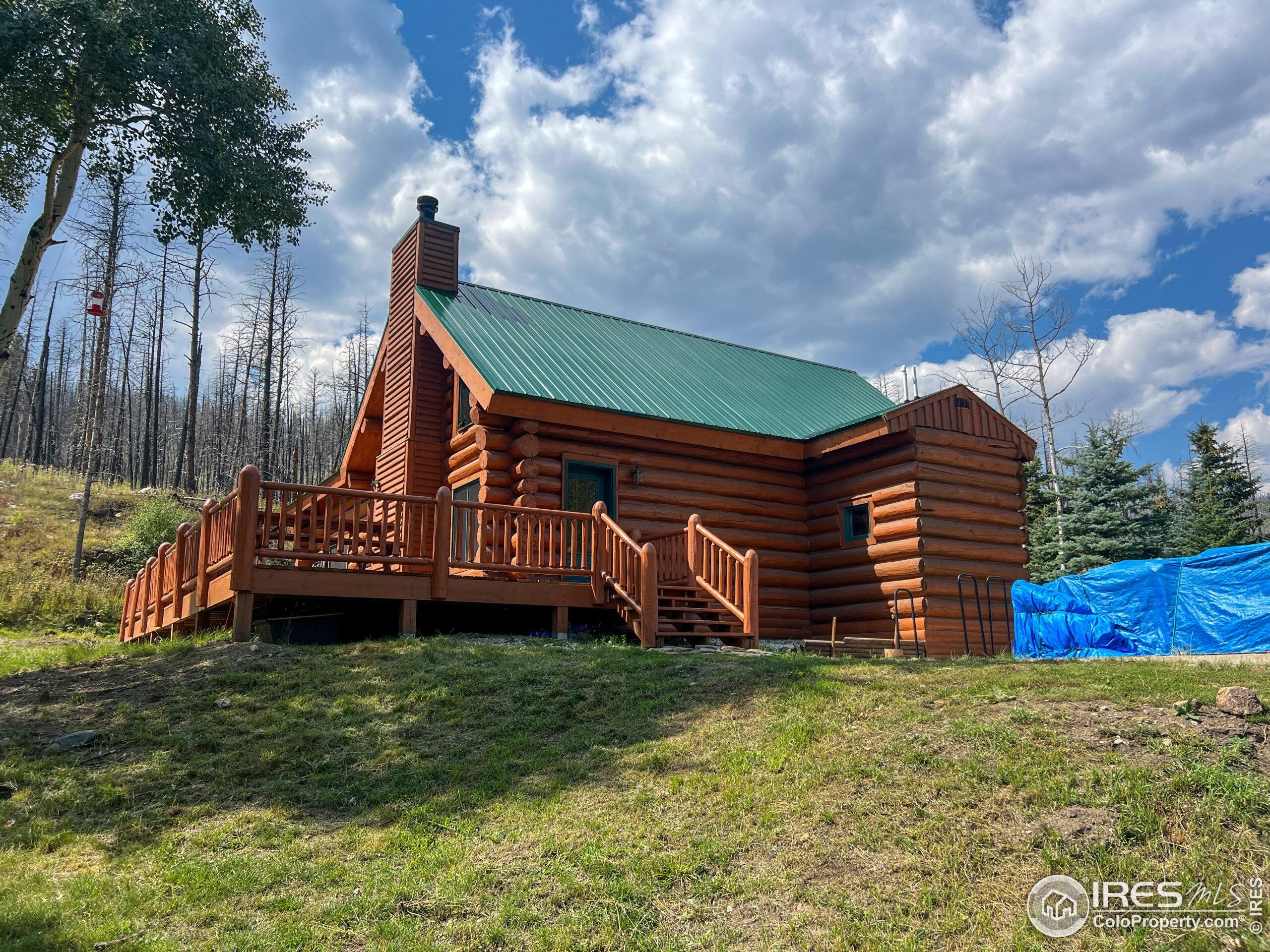 27667 Buckhorn Road Bellvue, CO 80512 - Photo 4 of 40 a wooden fence with some trees in the background