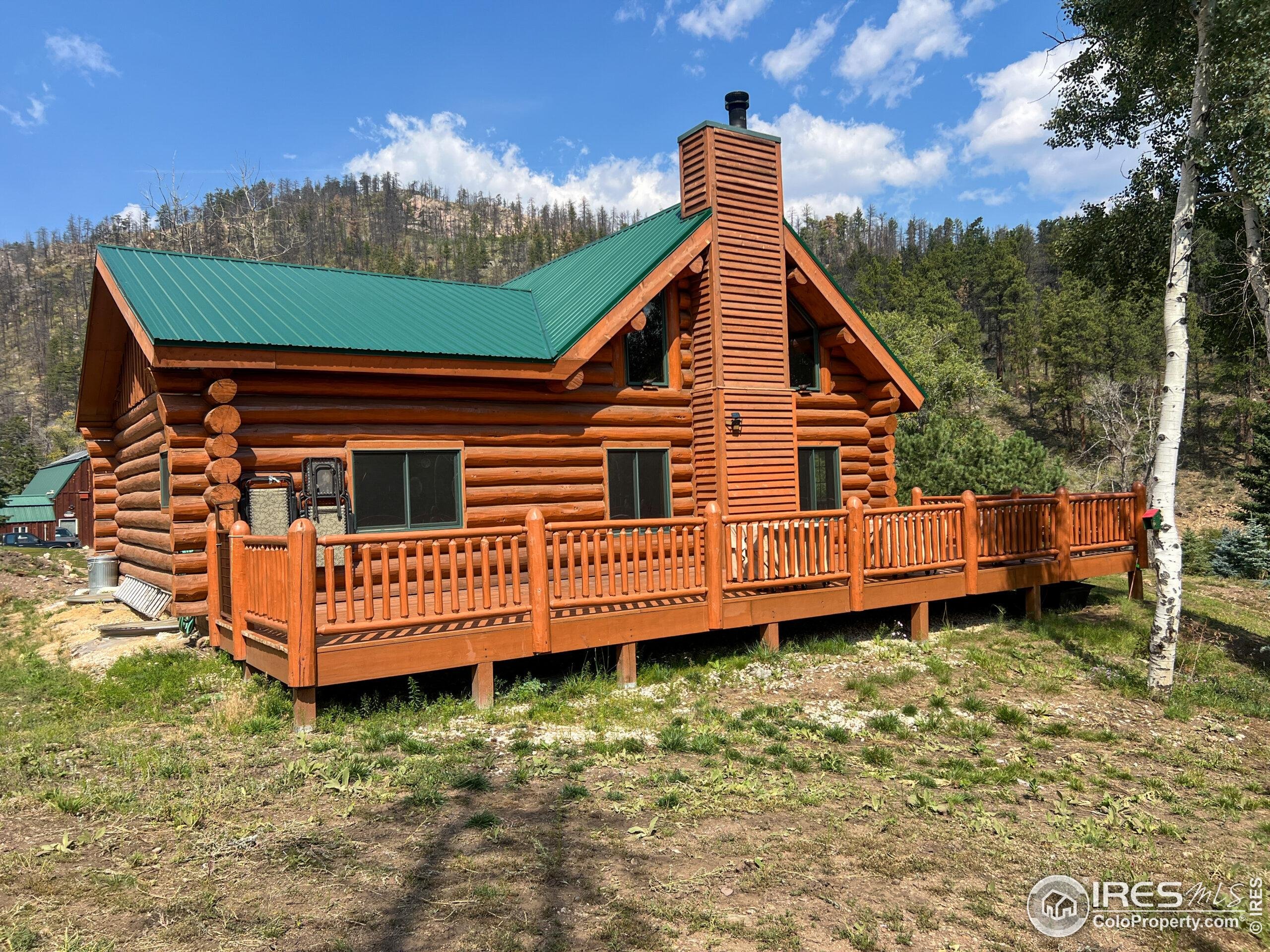 27667 Buckhorn Road Bellvue, CO 80512 - Photo 5 of 40 a view of a house with a wooden deck and a yard