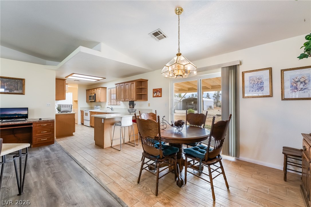 3631 South Blagg Road Pahrump, NV 89048 - Photo 11 of 47 A welcoming dining area seamlessly connects to the kitchen, offering a serene view of the expansive outdoor landscape.
