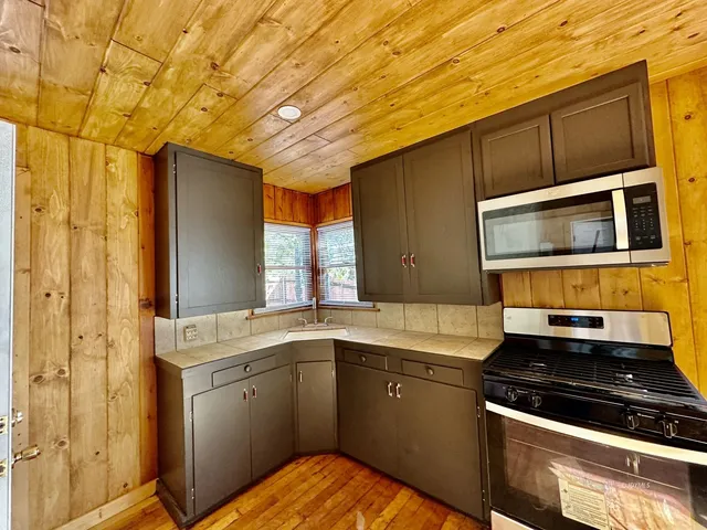 a kitchen with stainless steel appliances a sink stove and cabinets