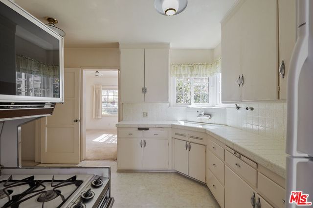 a view of a kitchen with refrigerator and cabinets