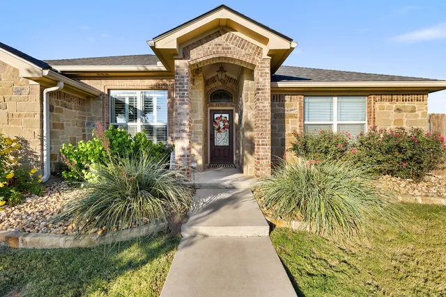 a front view of a house with a garden