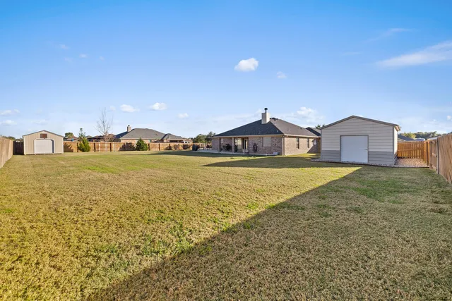 a view of a backyard with wooden fence