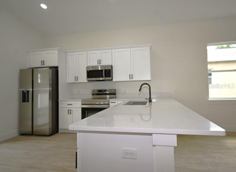 36755 Thomas Jefferson Road Dade City, FL 33525 - Photo 11 of 33 a kitchen with stainless steel appliances a sink stove and refrigerator