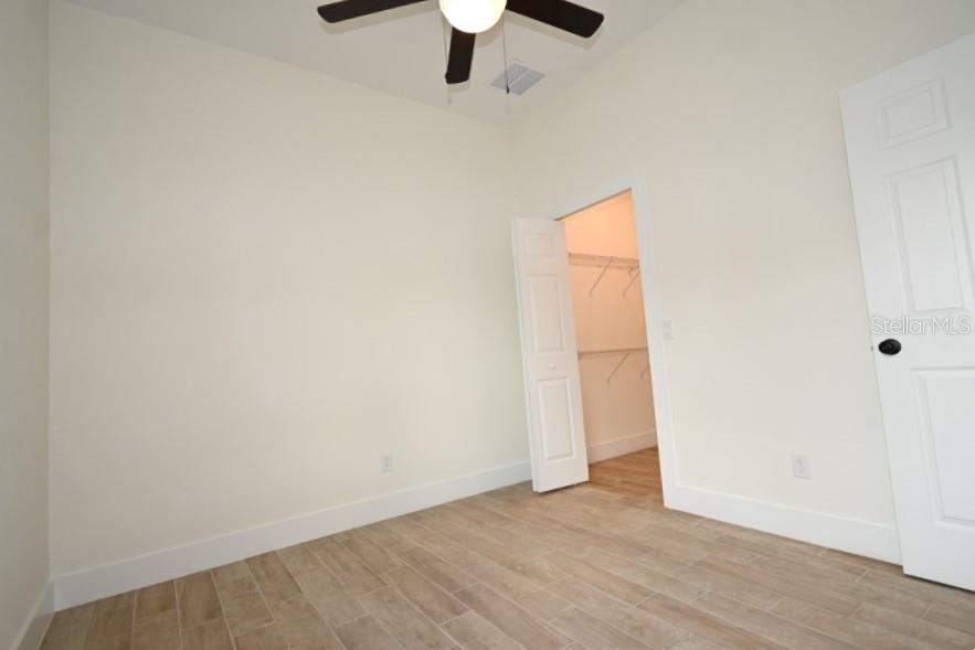 36755 Thomas Jefferson Road Dade City, FL 33525 - Photo 20 of 33 an empty room with a ceiling fan and wooden floor