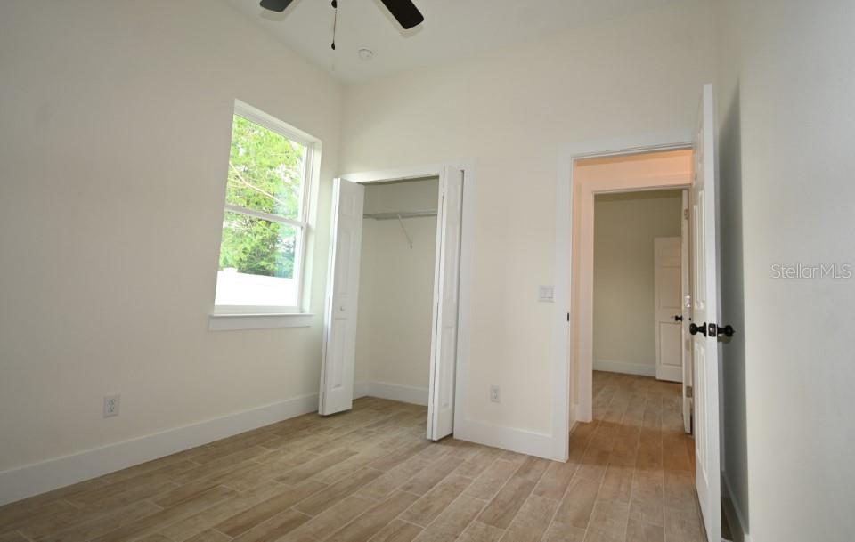 36755 Thomas Jefferson Road Dade City, FL 33525 - Photo 25 of 33 an empty room with wooden floor and a window