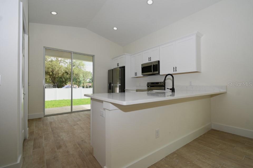 36755 Thomas Jefferson Road Dade City, FL 33525 - Photo 8 of 33 a kitchen with a sink a counter top space cabinets and stainless steel appliances