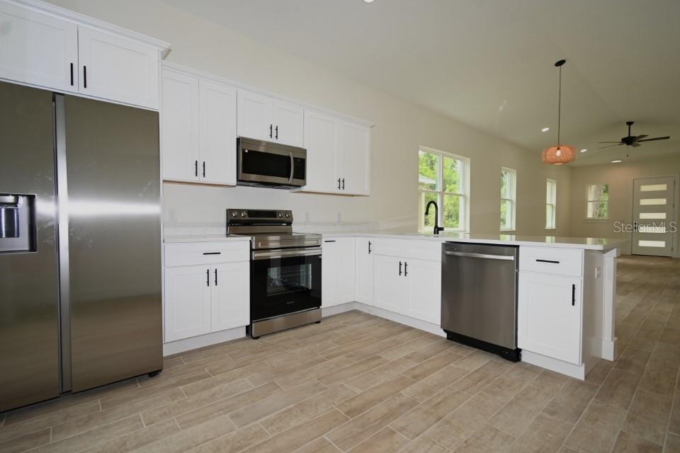 36755 Thomas Jefferson Road Dade City, FL 33525 - Photo 10 of 33 a kitchen with granite countertop a refrigerator a sink dishwasher a stove and a refrigerator