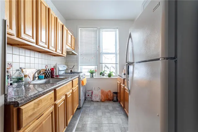 a kitchen with stainless steel appliances granite countertop a refrigerator and a sink