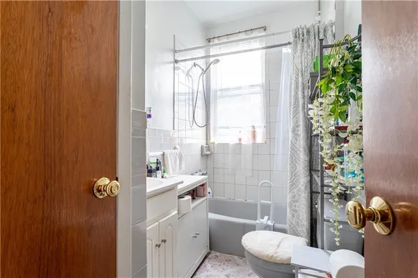 a bathroom with a shower sink vanity mirror and toilet