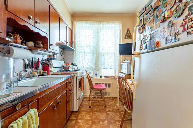 a room with stainless steel appliances a sink and a refrigerator