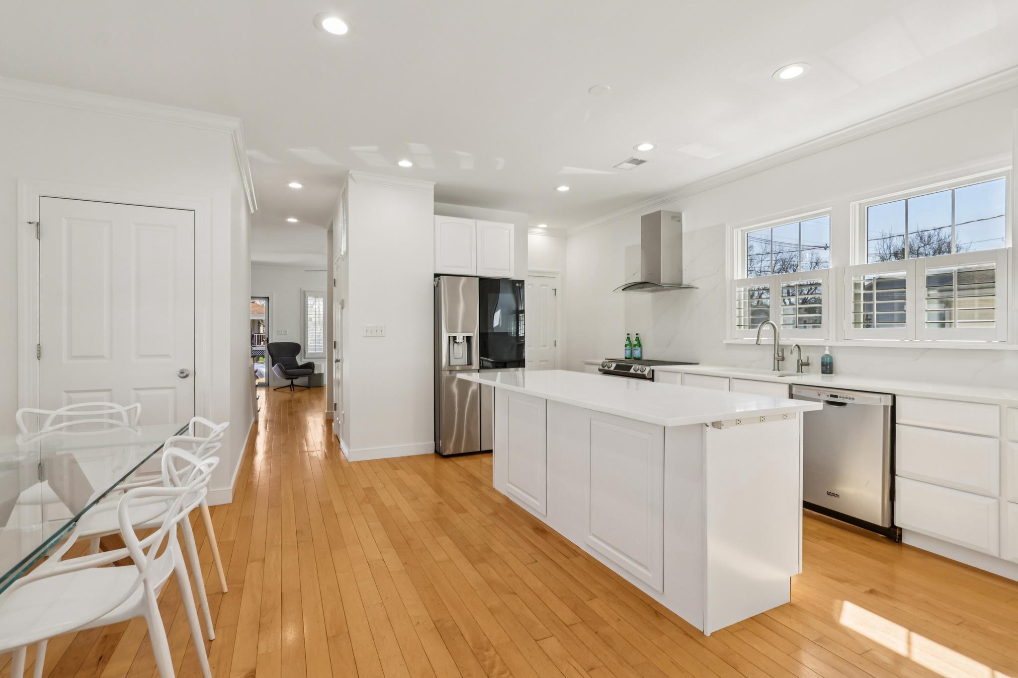 228 South Main Street Pennington, NJ 08534 - Photo 7 of 37 a large white kitchen with stainless steel appliances granite countertop a stove a sink a refrigerator and white cabinets with wooden floor