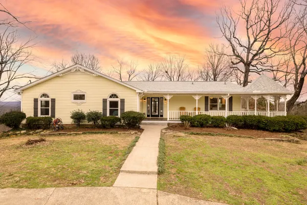 a view of a house with a yard patio and fire pit