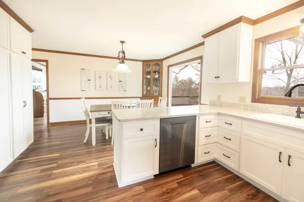 a view of a dining room and livingroom with furniture wooden floor a chandelier