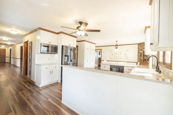 a kitchen with stainless steel appliances a refrigerator and wooden floor