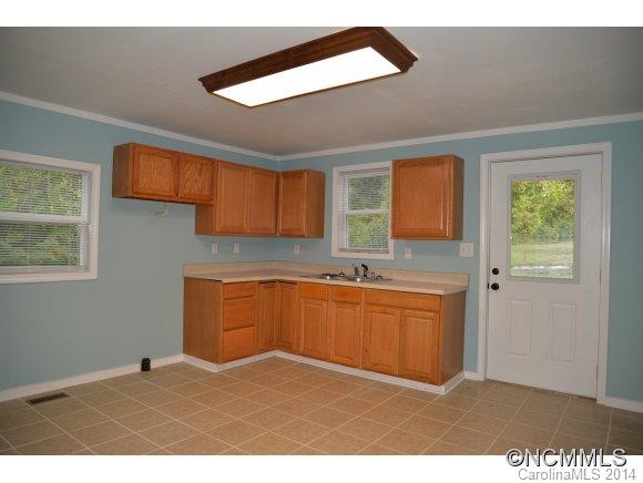 40 Lyle Street Tryon, NC 28782 - Photo 8 of 16 a kitchen with granite countertop a sink cabinets and wooden floor