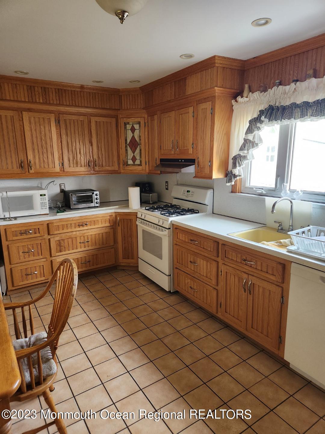 14 Grove Street Long Branch, NJ 07740 - Photo 10 of 21 a kitchen with a sink a stove cabinets and a window
