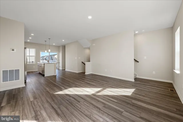 a view of a living room and kitchen with a wooden floor