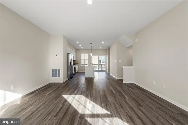 a view of a kitchen with wooden floor and a window