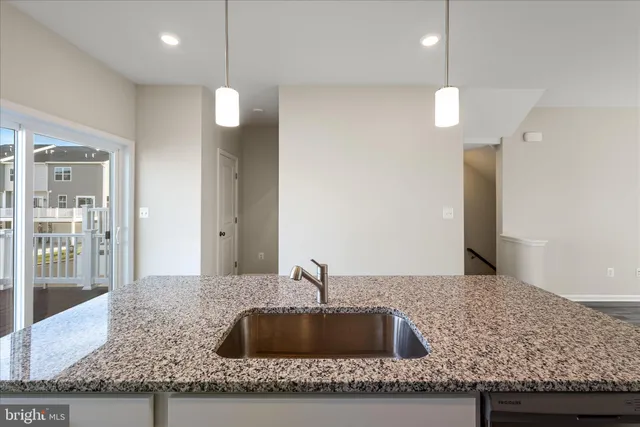 a kitchen with granite countertop a sink a counter and wooden cabinets