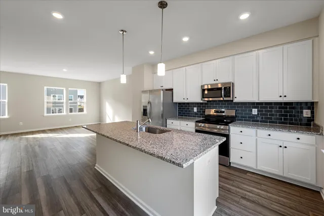 a kitchen with kitchen island granite countertop stainless steel appliances a stove sink and microwave