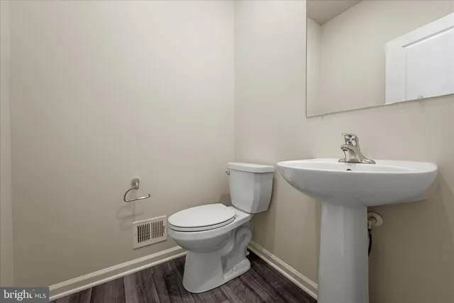 a bathroom with a sink toilet and a mirror