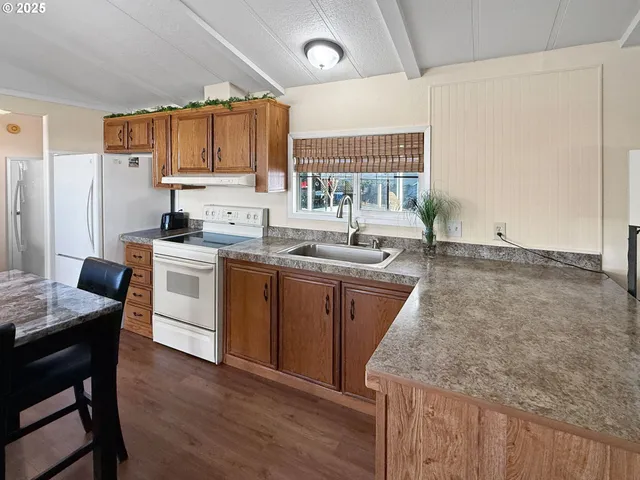 a kitchen with granite countertop a sink appliances a counter space and cabinets