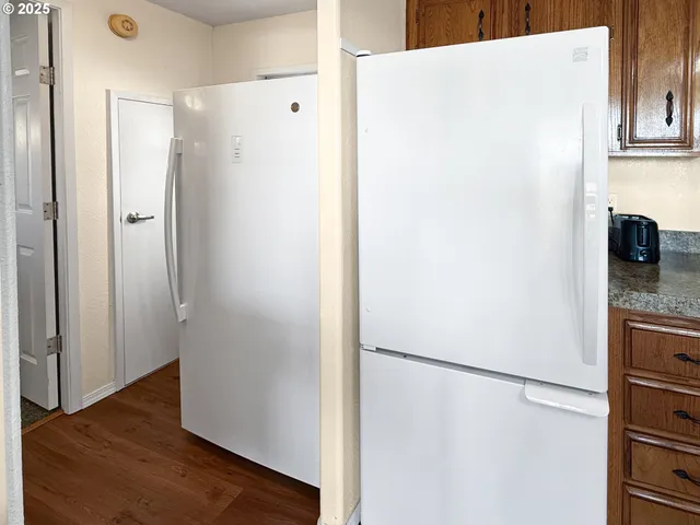 a view of kitchen with refrigerator and wooden floor