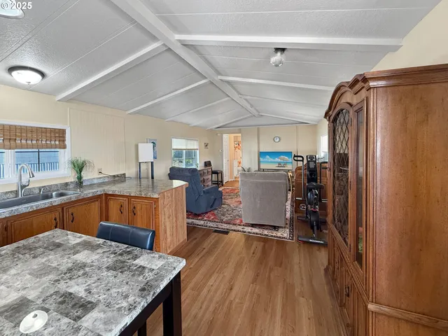 a kitchen with stainless steel appliances granite countertop lots of counter top space and wooden floor