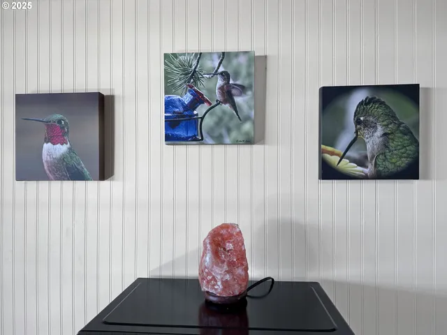a hallway with a painting on the wall and a potted plant