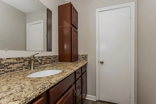 a bathroom with a granite countertop sink and a mirror