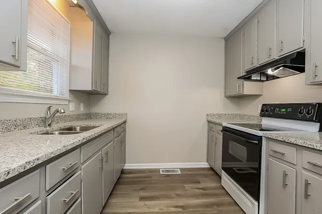 a kitchen with stainless steel appliances granite countertop a sink stove and cabinets