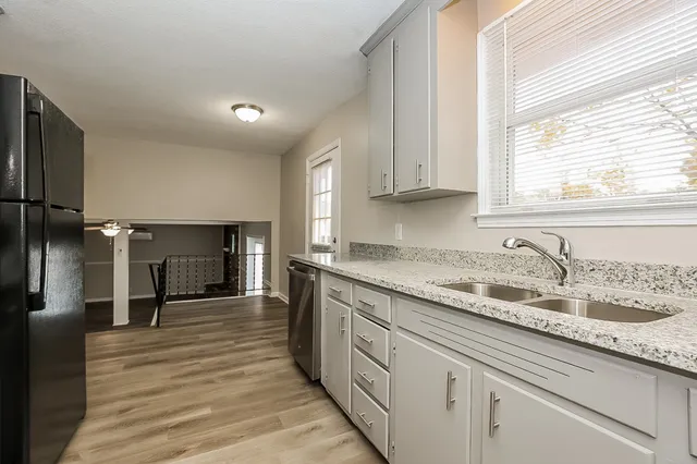 a kitchen with granite countertop a sink and cabinets