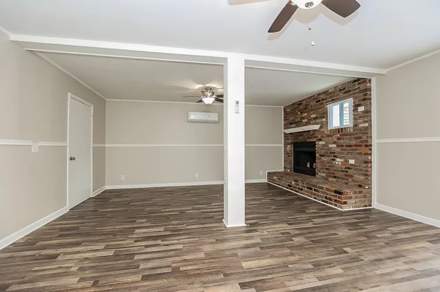 a view of a livingroom with wooden floor staircase and a kitchen space