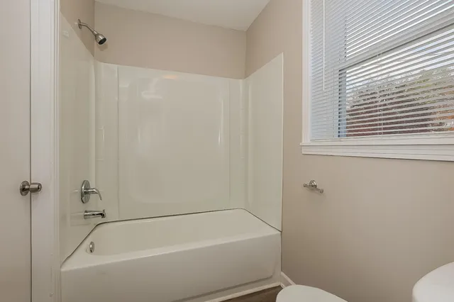 a white bath tub sitting next to a toilet