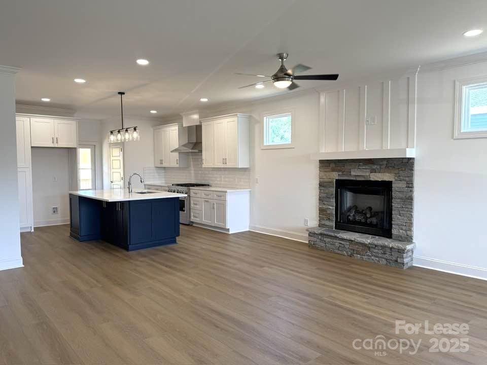 8070 Blackwood Road Denver, NC 28037 - Photo 15 of 39 a view of kitchen with kitchen island a sink wooden floor and a fireplace